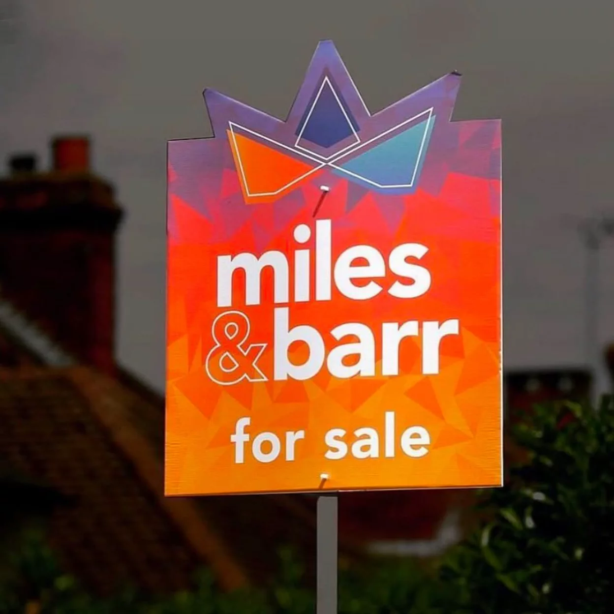 A Miles and Barr for sale board with a mirrored crown detail