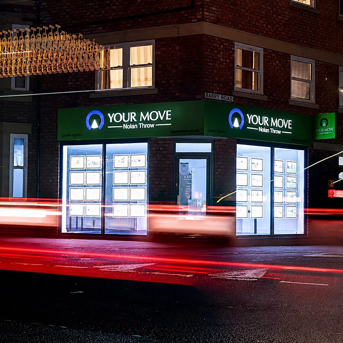 An illuminated Your Move office fascia lit at night